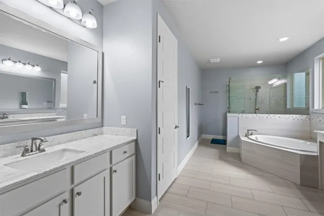 a bathroom with a granite countertop sink mirror and bathtub