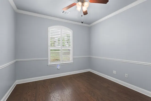 an empty room with wooden floor closet and windows