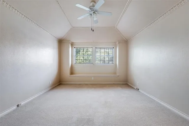 an empty room with a window and a ceiling fan