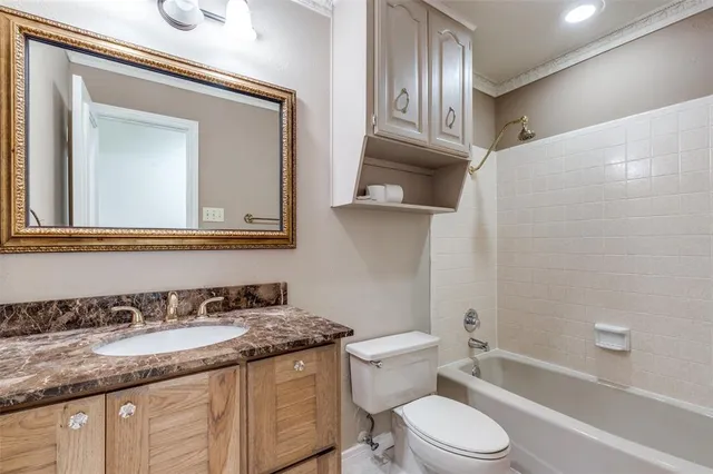 a bathroom with a granite countertop toilet sink and mirror