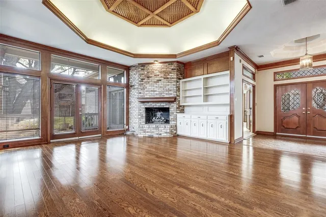a view of a livingroom with wooden floor and a fireplace