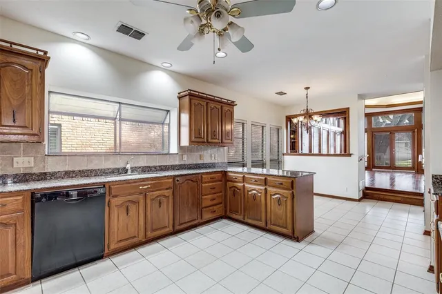 a large kitchen with stainless steel appliances granite countertop a sink and dishwasher a stove top oven with wooden floor