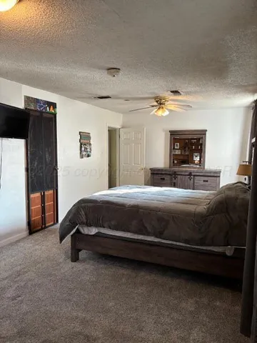 a spacious bedroom with a bed a couch and large window