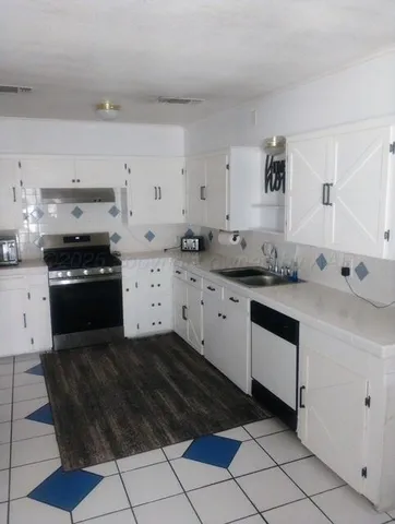 a kitchen with stainless steel appliances a sink stove and cabinets