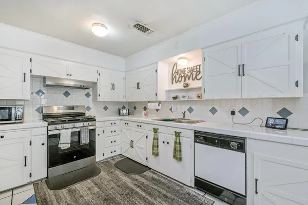 a kitchen with stainless steel appliances a refrigerator sink and stove