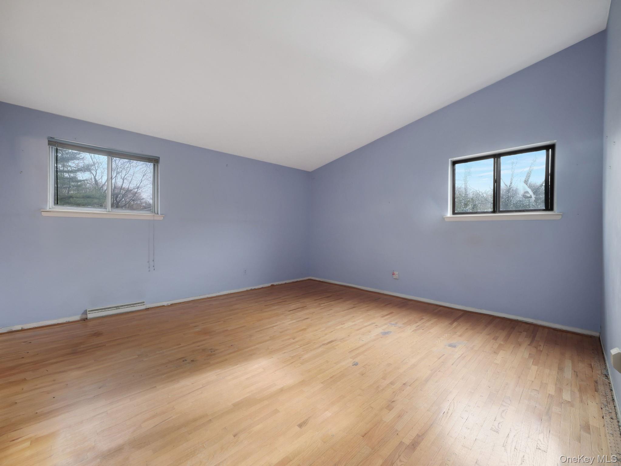6 Pennington Way Spring Valley, NY 10977 - Photo 15 of 34 Bedroom featuring lofted ceiling, light wood finished floors, plenty of natural light, and baseboard heating