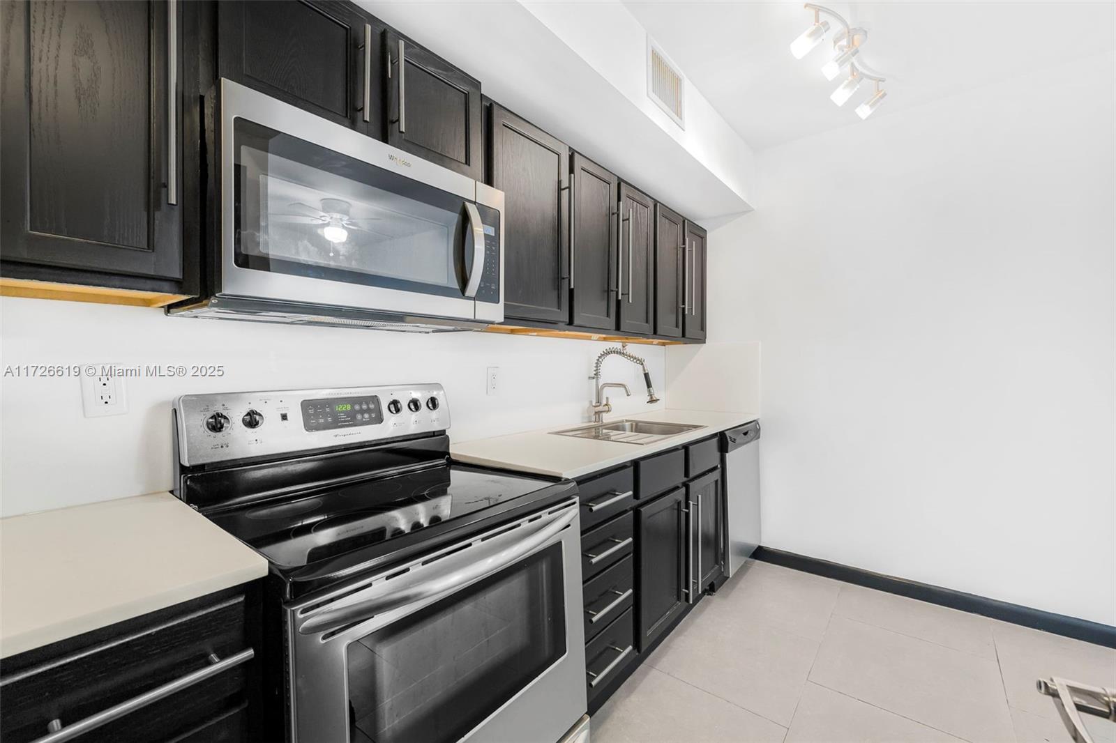 1876 Southwest 11th Terrace, Unit 302 Miami, FL 33135 - Photo 1 of 15 a kitchen with a stove and a microwave