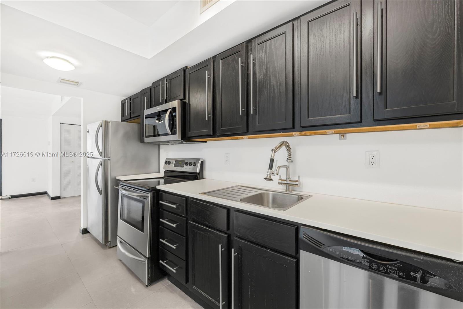 1876 Southwest 11th Terrace, Unit 302 Miami, FL 33135 - Photo 2 of 15 a kitchen with a sink appliances and cabinets