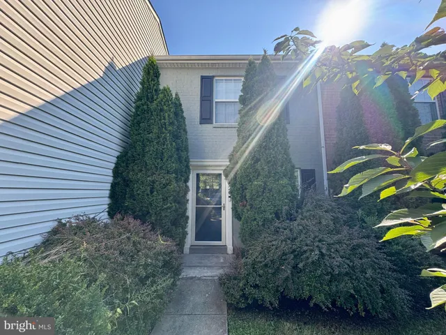 a view of an empty room with wooden floor and stairs