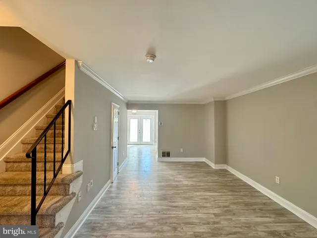 a view of a livingroom with wooden floor and a staircase