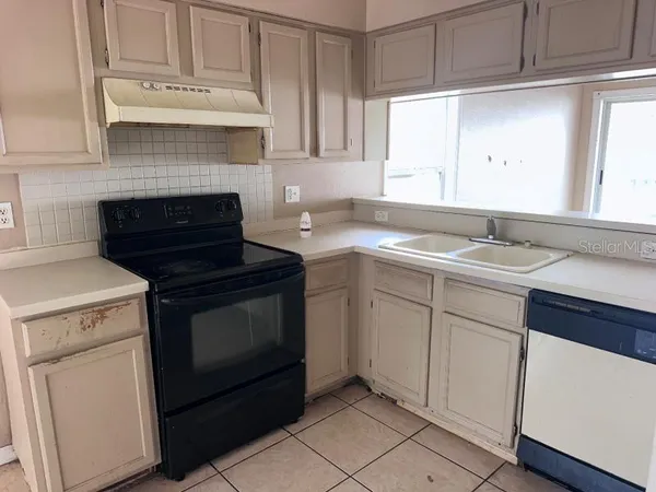 a kitchen with cabinets appliances and a window