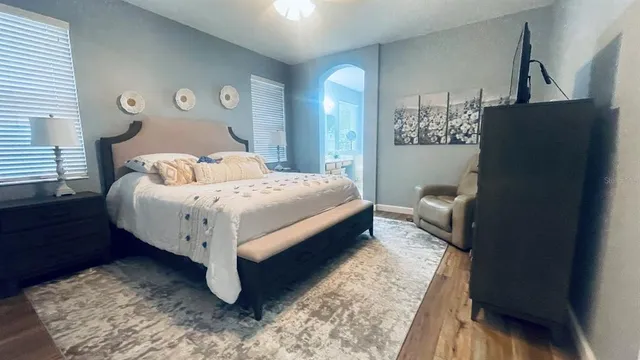 a bedroom with a bed lamp and a dresser
