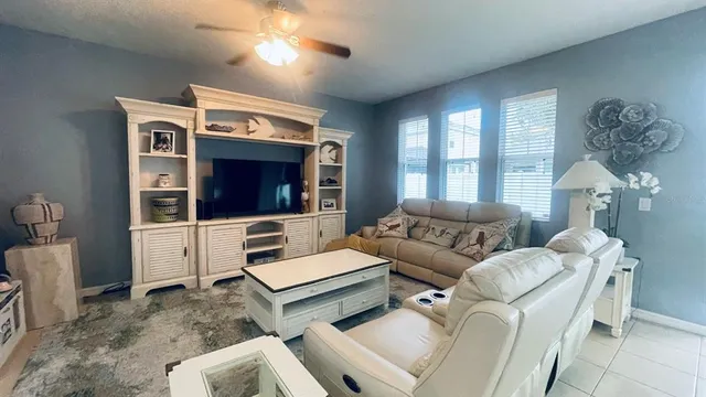 a living room with furniture a large window and a flat screen tv