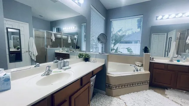 a bathroom with a tub double sink and mirror