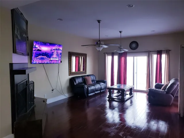 a kitchen with stainless steel appliances granite countertop a stove a sink dishwasher and a dining table with wooden floor