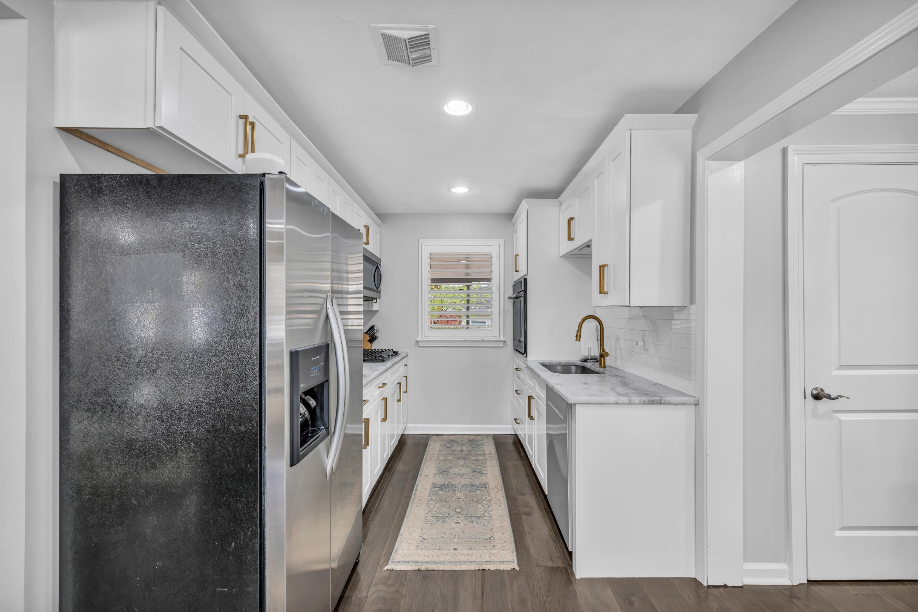 5051 Dee Road Memphis, TN 38117 - Photo 7 of 32 a view of a kitchen with a sink and dishwasher a refrigerator with white cabinets