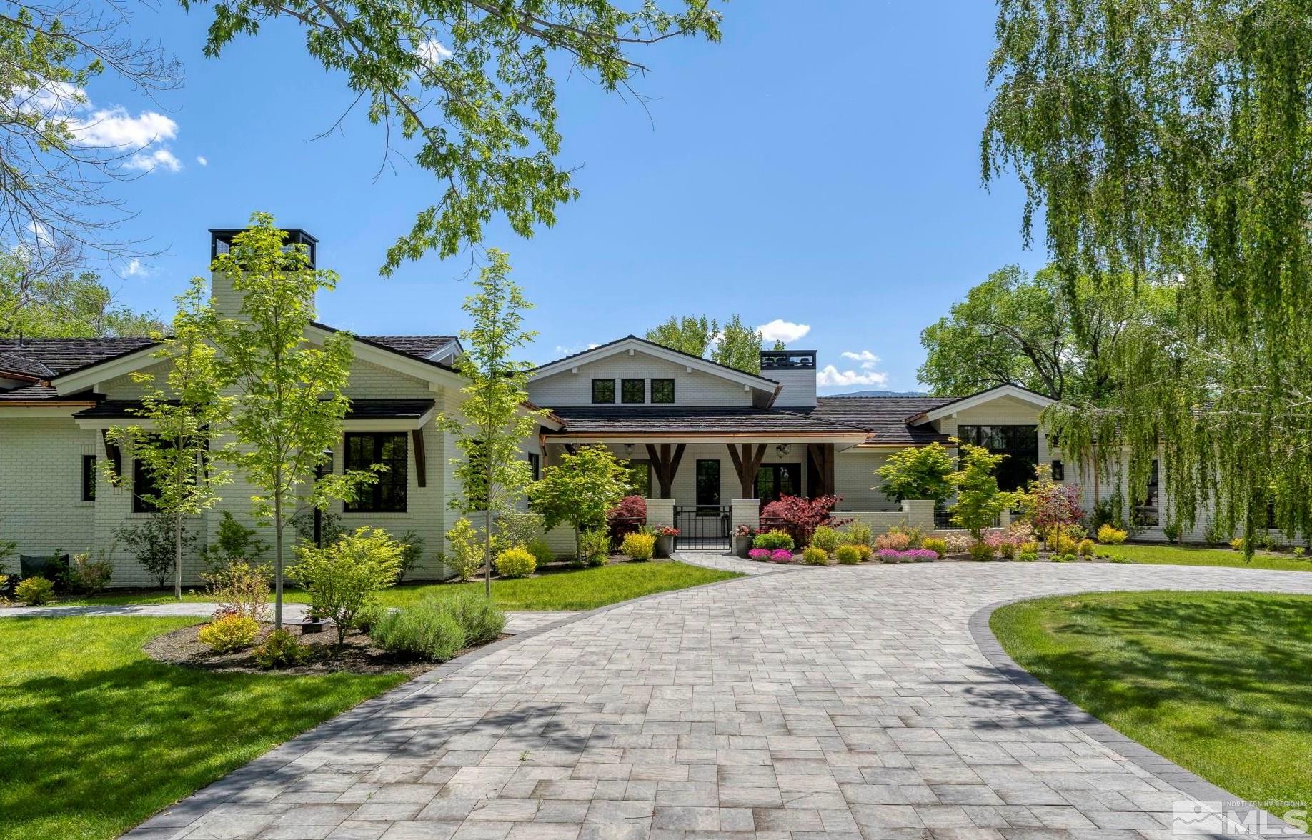a front view of a house with a yard and potted plants