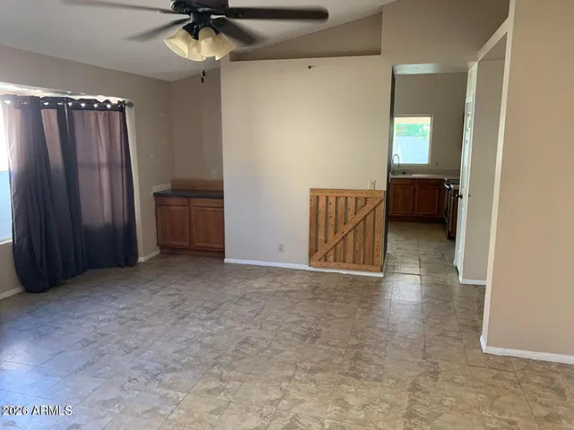 an empty room with a mirror and a ceiling fan