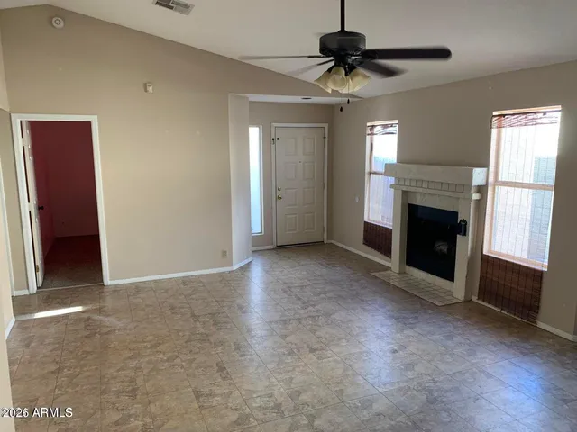 a view of an empty room with window and fire place