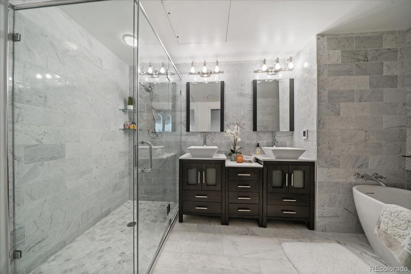 1610 Little Raven Street, Unit PH5 Denver, CO 80202 - Photo 31 of 44 a bathroom with a sink vanity granite tub shower and mirror