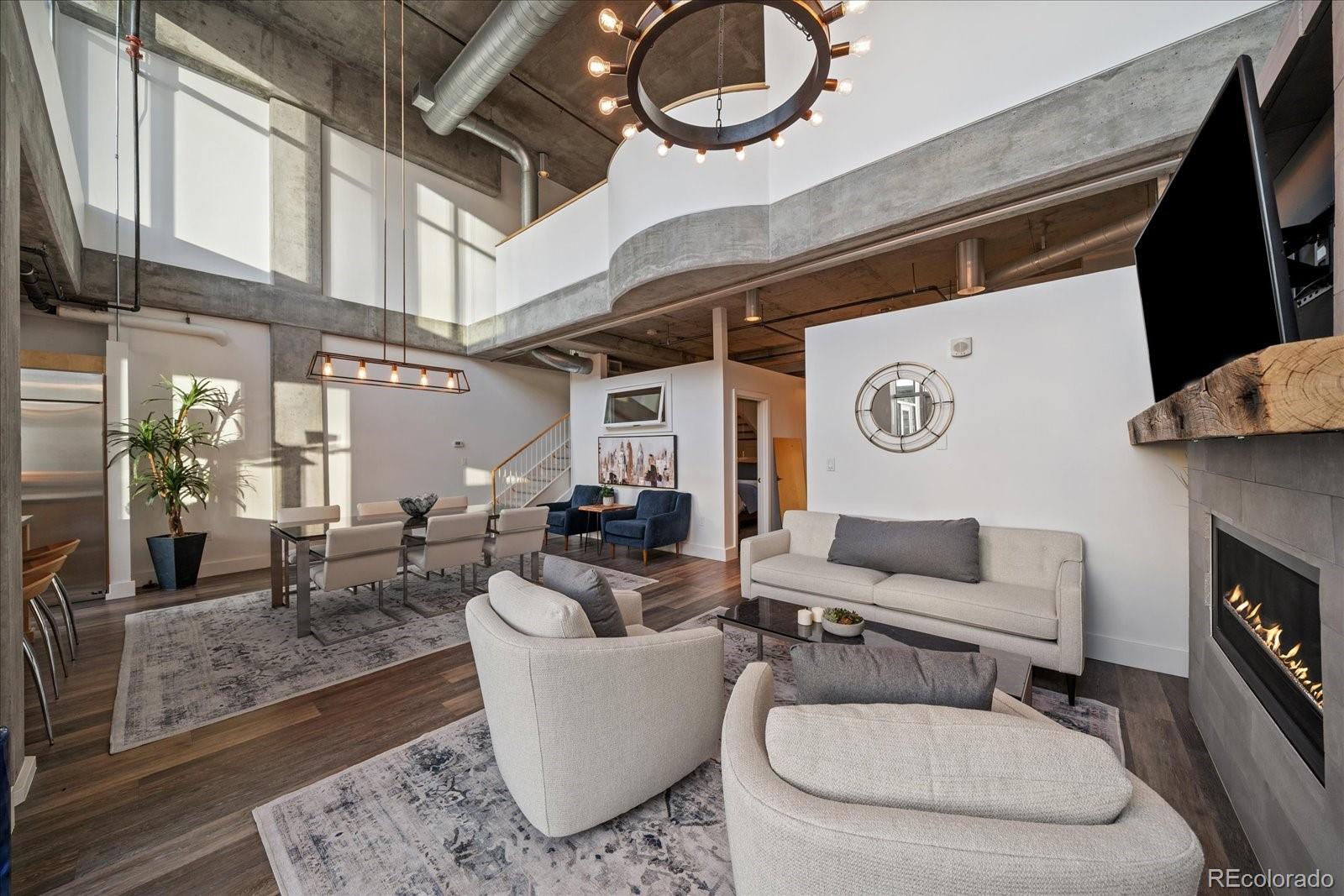 1610 Little Raven Street, Unit PH5 Denver, CO 80202 - Photo 10 of 44 a living room with furniture a rug and a fireplace