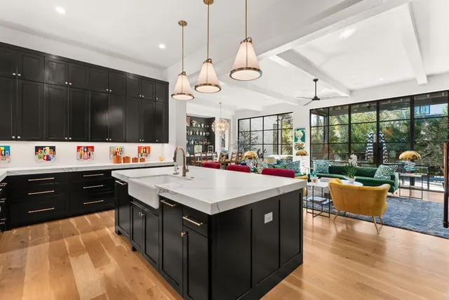 a large kitchen with a counter space a sink appliances and a large window