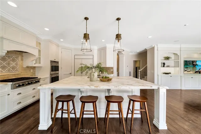 a large kitchen with stainless steel appliances a lot of counter space and wooden floor