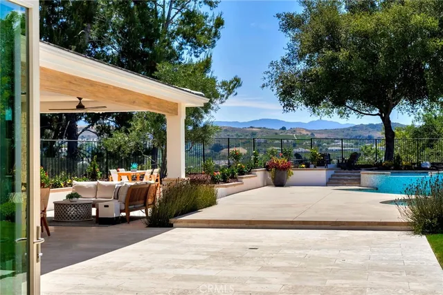 a view of a patio with couches potted plants and a big yard
