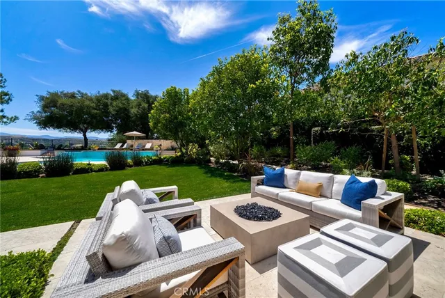 a view of a house with backyard sitting area and swimming pool