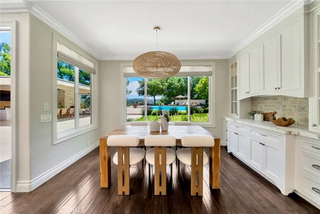 a kitchen with stainless steel appliances kitchen island granite countertop a kitchen island and chairs in it