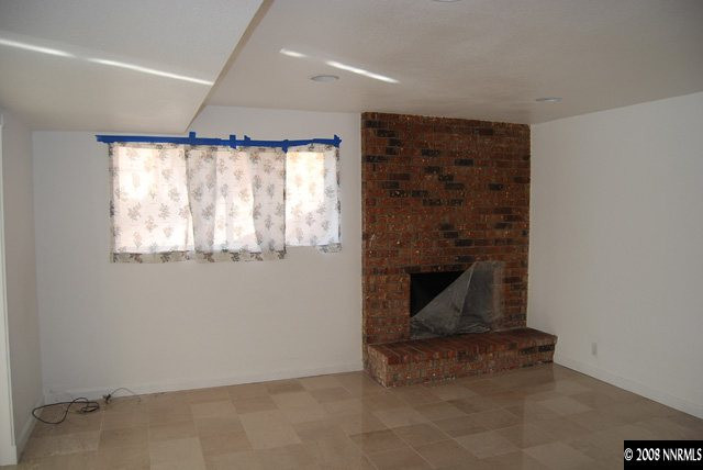 1445 Kings Row Reno, NV 89503 - Photo 4 of 9 an empty room with a fireplace and window