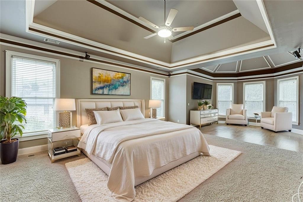 940 Chateau Forest Road Hoschton, GA 30548 - Photo 32 of 87 a spacious bedroom with a bed a couch and a window