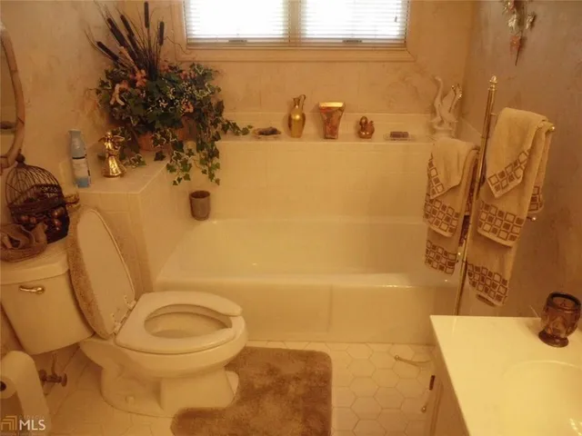 a white toilet sitting next to a bath tub