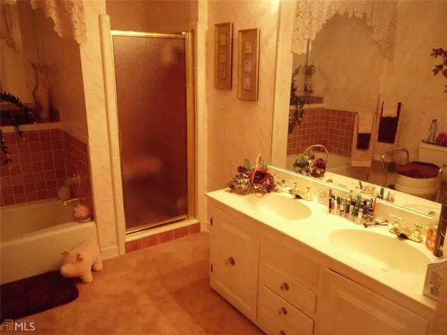 a bathroom with a double vanity sink a mirror and a bathtub