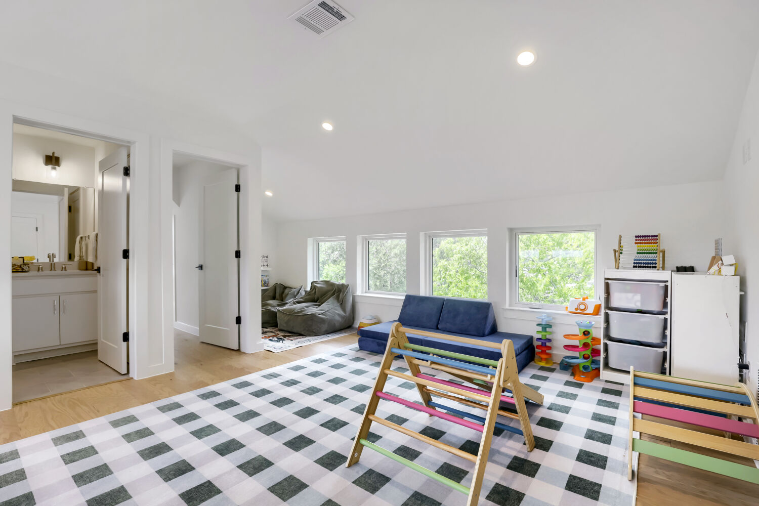 4804 Ribbecke Avenue, Unit A Austin, TX 78721 - Photo 6 of 32 The property features light hardwood floors, white walls, recessed lighting, and multiple windows that provide natural light