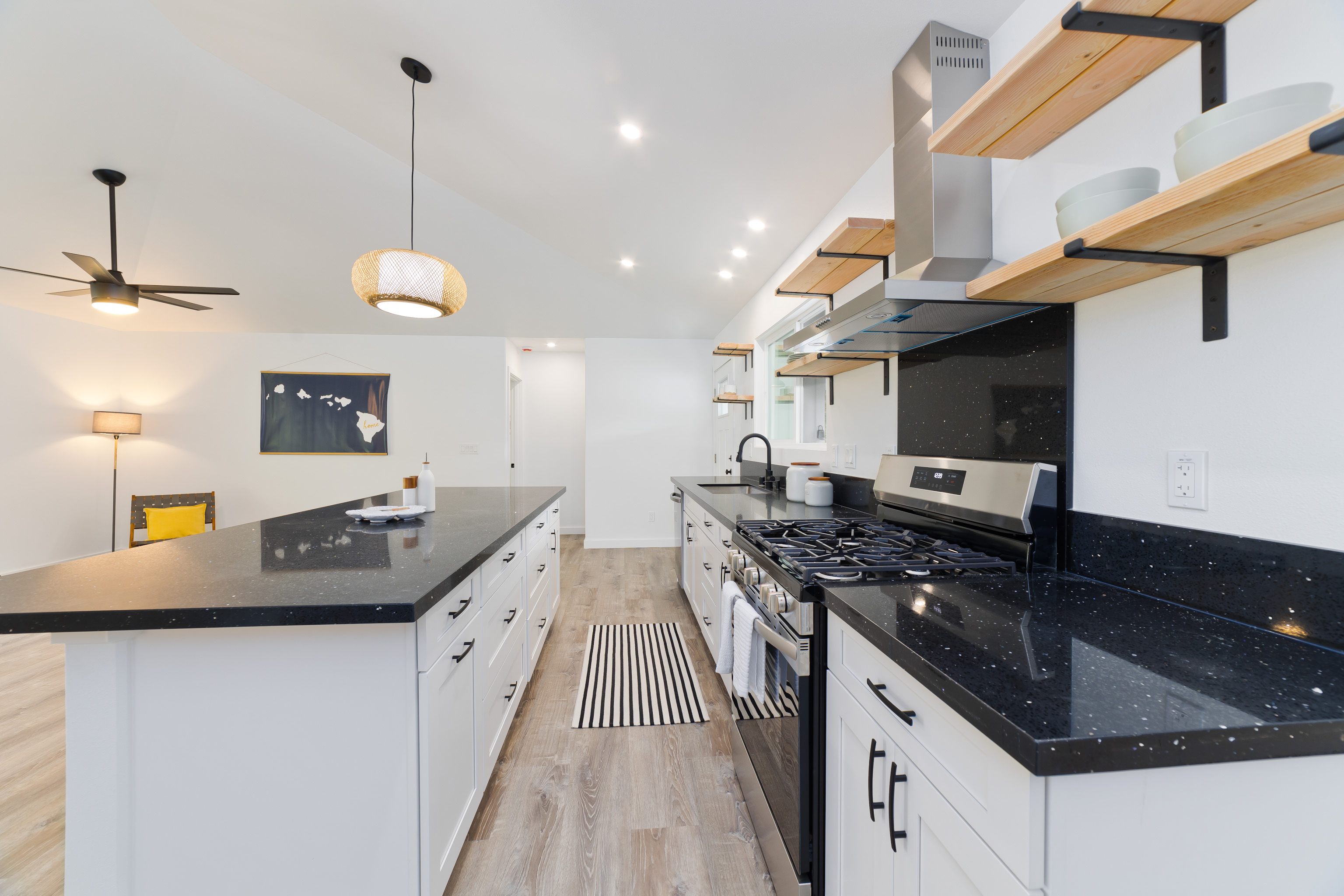 99-2016 Pukeawe Circle Volcano, HI 96785 - Photo 5 of 28 a kitchen with stainless steel appliances granite countertop a sink a stove and a wooden floors