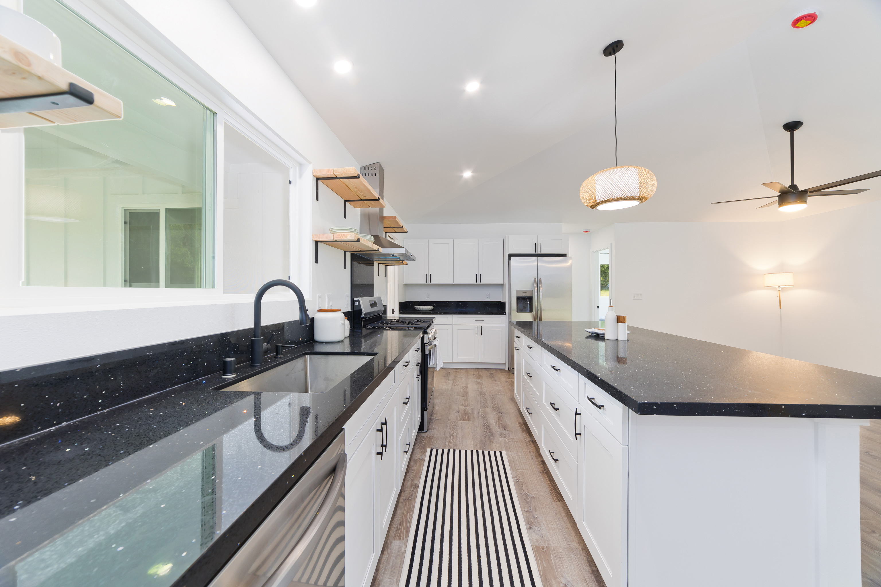 99-2016 Pukeawe Circle Volcano, HI 96785 - Photo 6 of 28 a kitchen with stainless steel appliances granite countertop a sink a stove and a wooden floors
