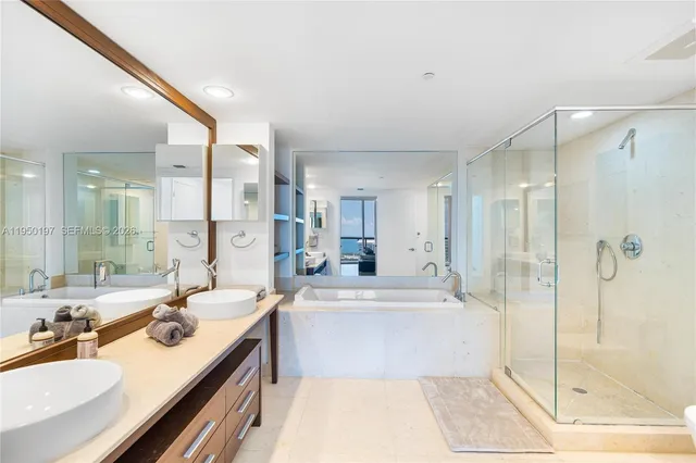 a bathroom with a tub sink shower and mirror