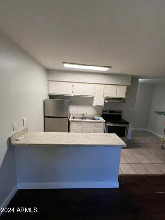 a kitchen with kitchen island sink stove and refrigerator
