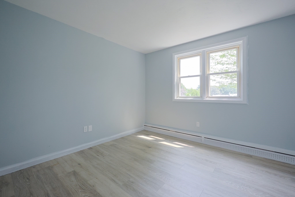 10 Nuttall Lane, Unit 1 Worcester, MA 01604 - Photo 19 of 28 an empty room with wooden floor and windows