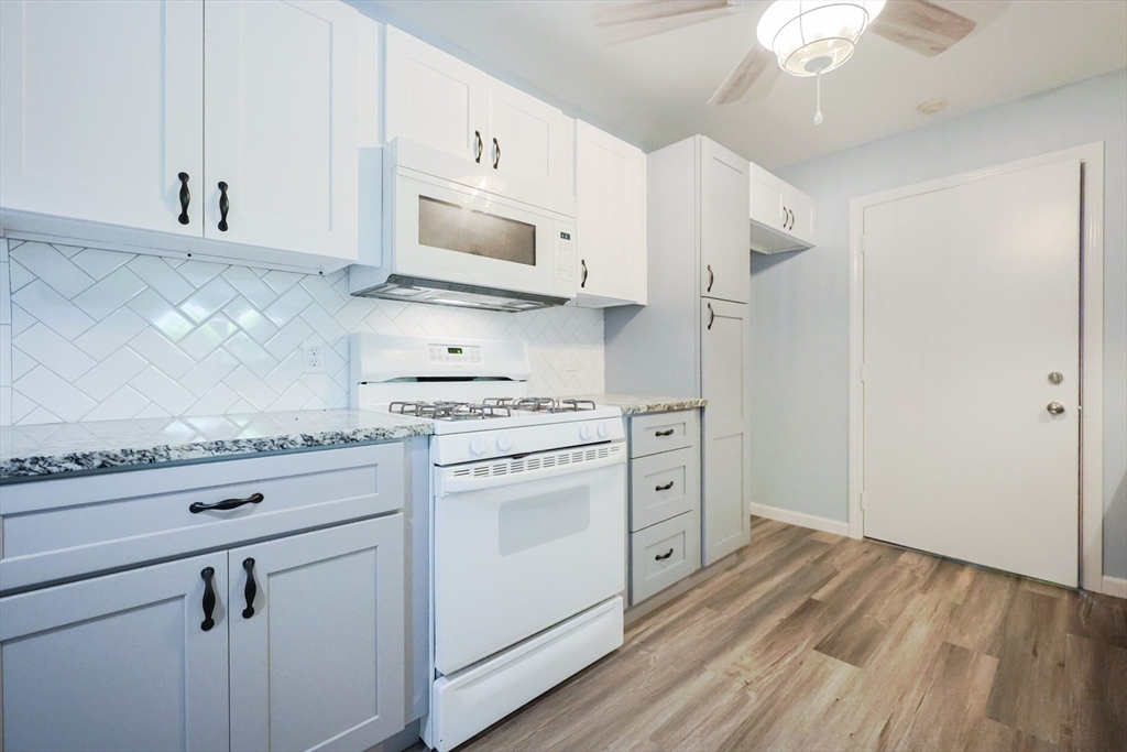10 Nuttall Lane, Unit 1 Worcester, MA 01604 - Photo 4 of 28 a kitchen with granite countertop white cabinets and white appliances