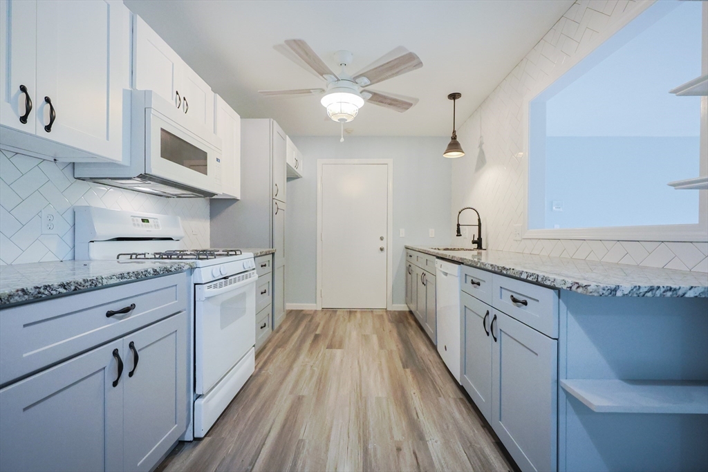 10 Nuttall Lane, Unit 1 Worcester, MA 01604 - Photo 6 of 28 a kitchen with stainless steel appliances granite countertop hardwood floor sink stove and white cabinets