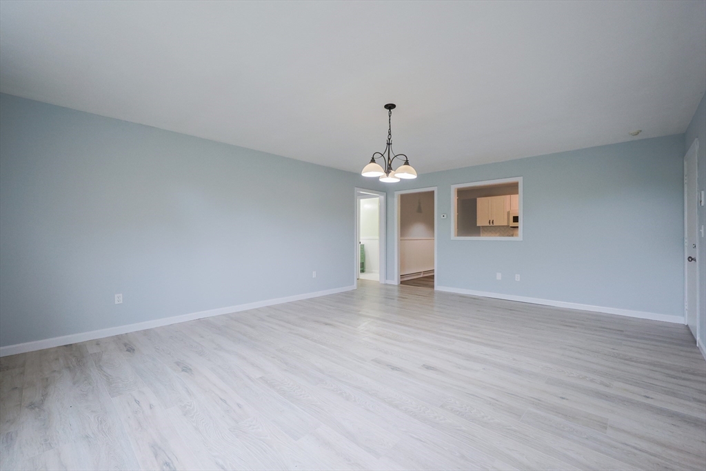 10 Nuttall Lane, Unit 1 Worcester, MA 01604 - Photo 7 of 28 a view of empty room with wooden floor and chandelier