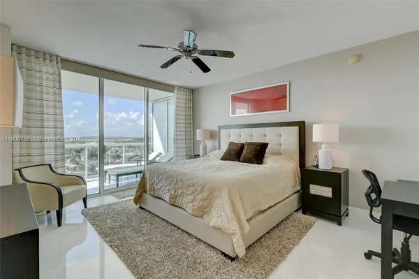 a bedroom with a bed and a large window