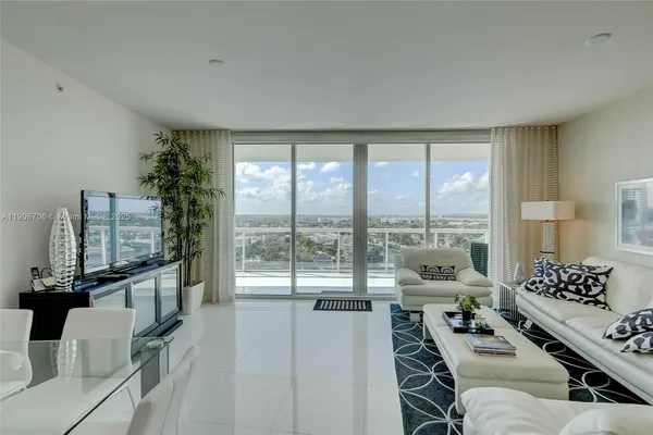 a living room with furniture and floor to ceiling window