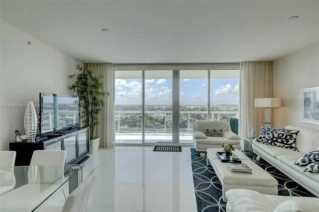 a living room with furniture and floor to ceiling window