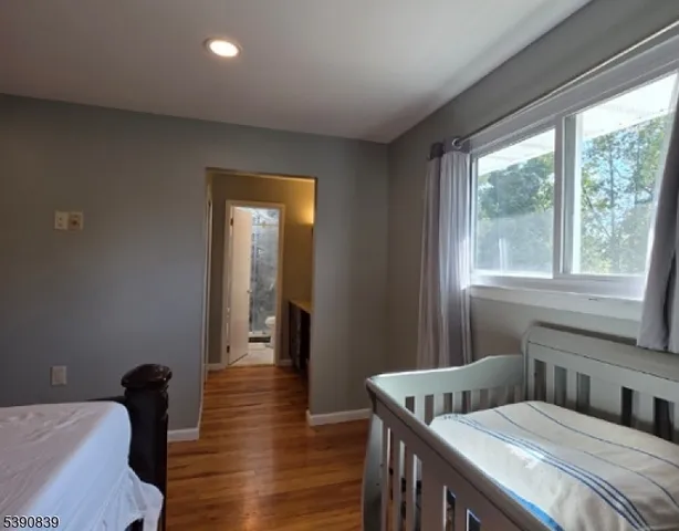 a bedroom with two beds and wooden floor