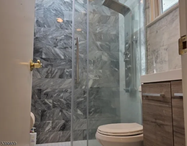 a white toilet sitting next to a shower