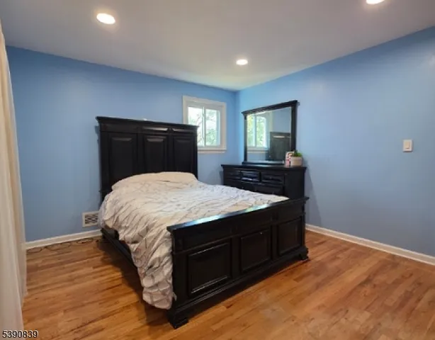 a bedroom with a bed and wooden floor