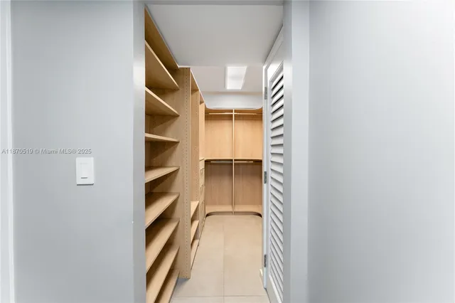 a view of walk in closet with empty racks